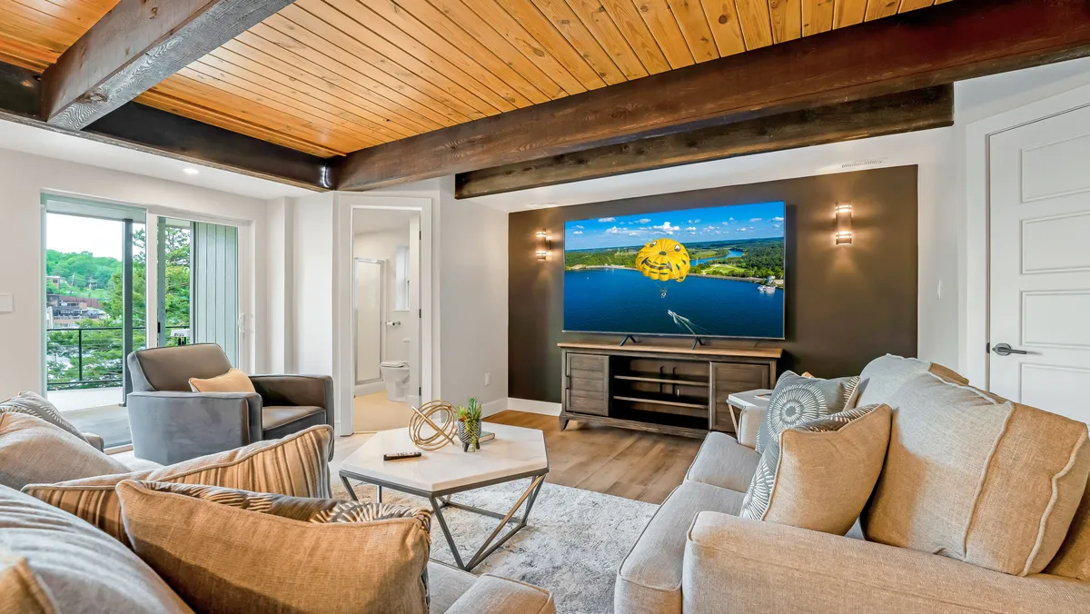 This image displays a comfortable seating arrangement centered around a large TV screen and a decorative coffee table. The space exudes a welcoming and homely mood, with plush seating that encourages relaxation, movie nights, and family gatherings.